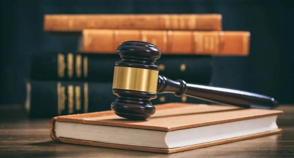 Judge gavel on a book, law books background, wooden desk